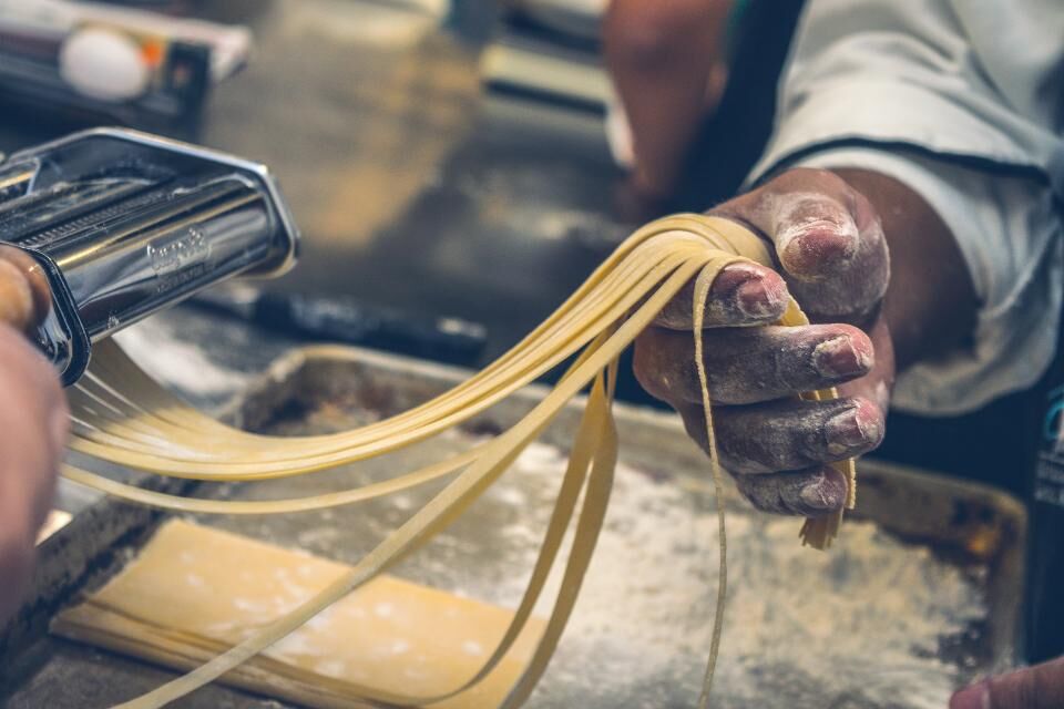 Manos estirando pasta fresca